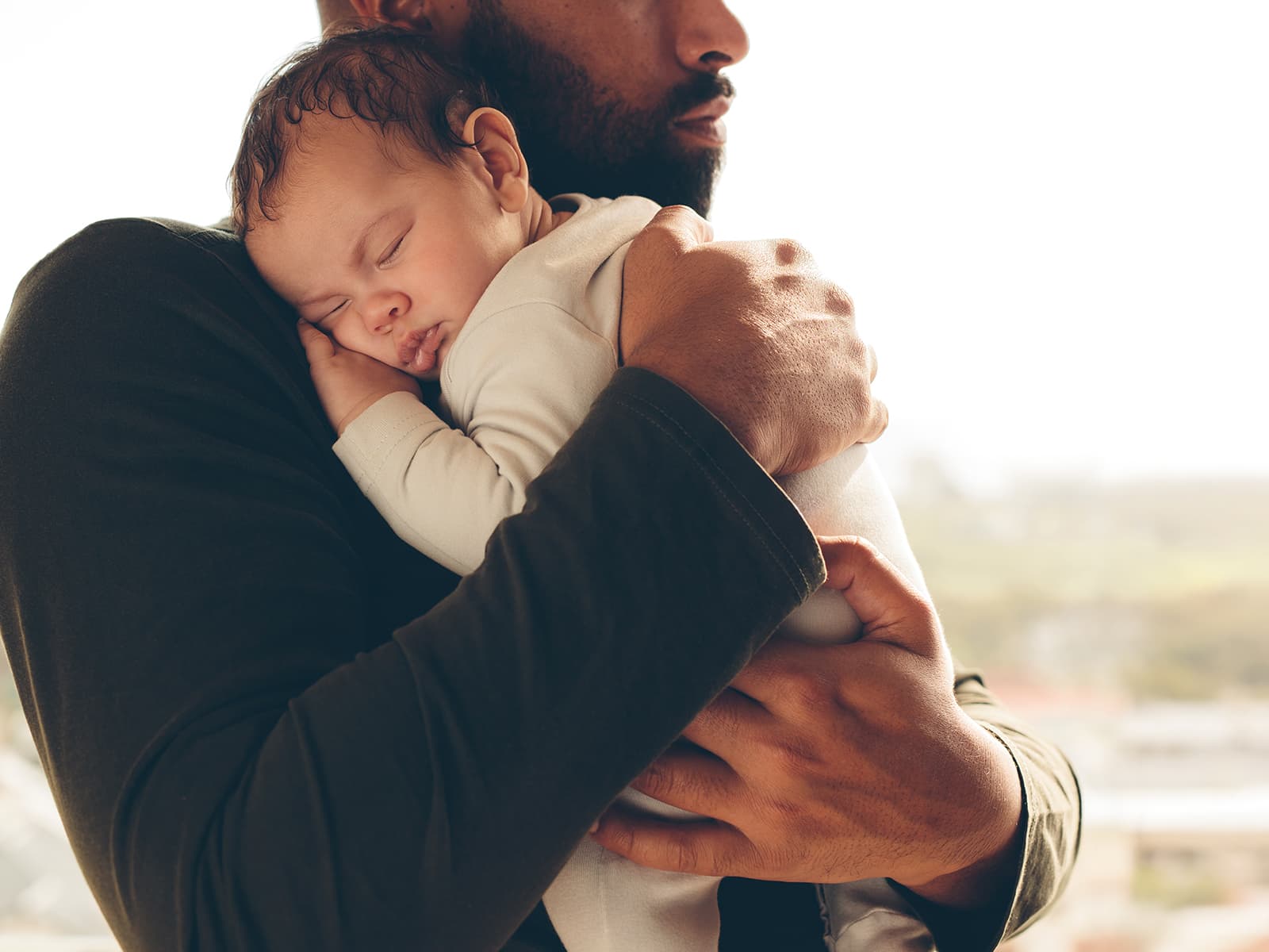 Man holding baby on his chest.